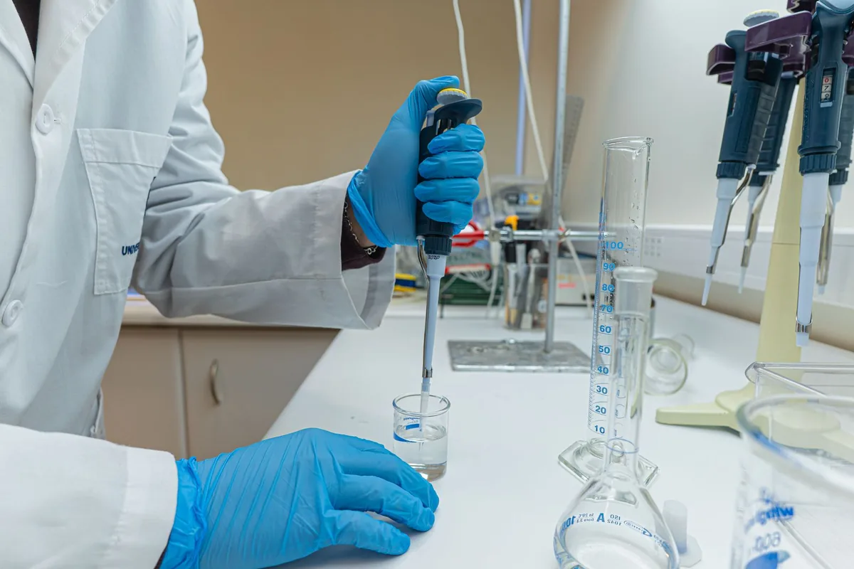 Científico pipeteando una muestra en el laboratorio